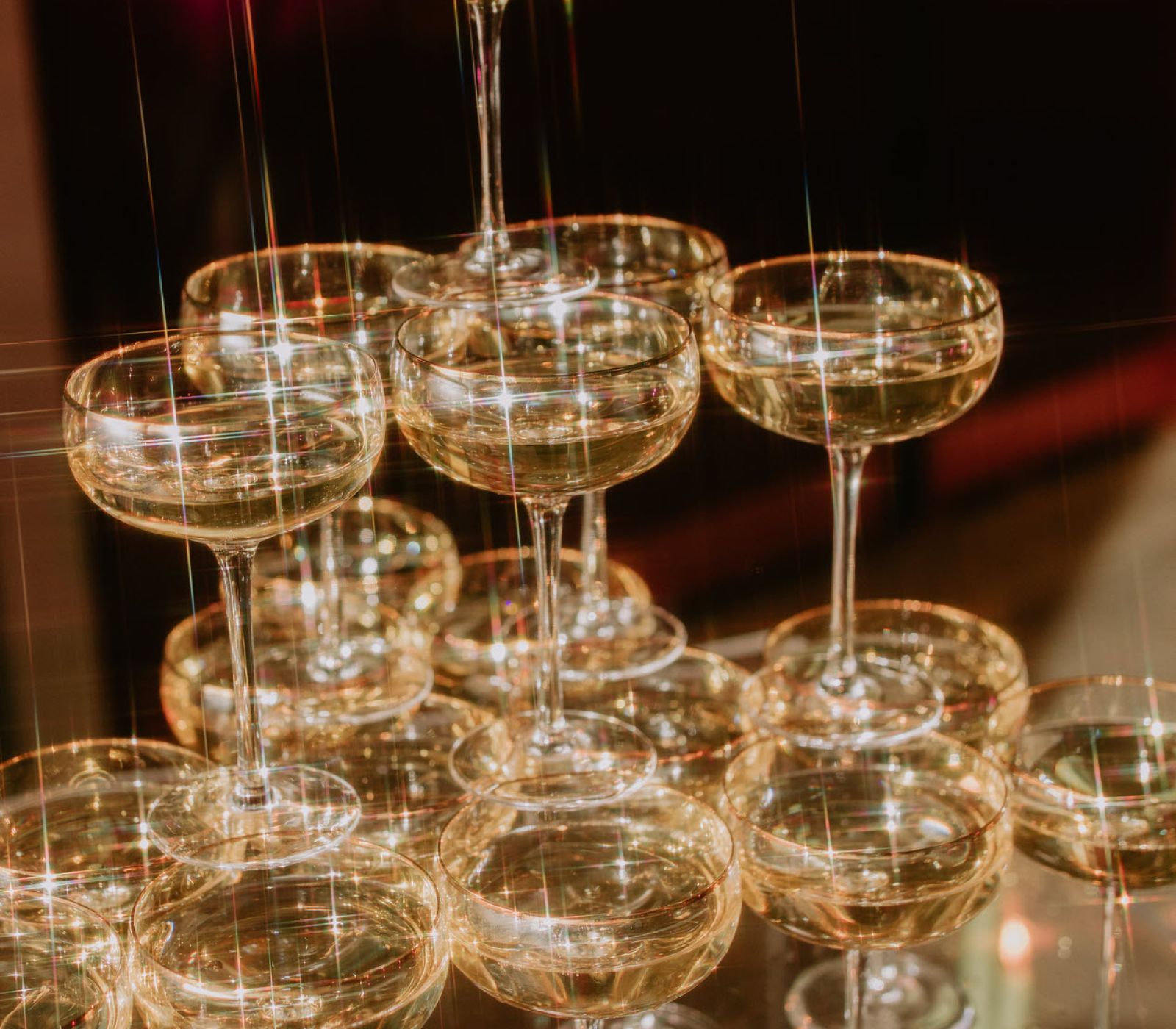 Champagne glasses in a tower configuration being filled.